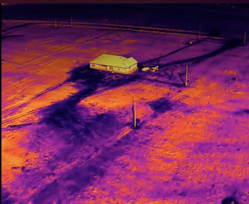 Aerial thermal view of a house and surrounding terrain